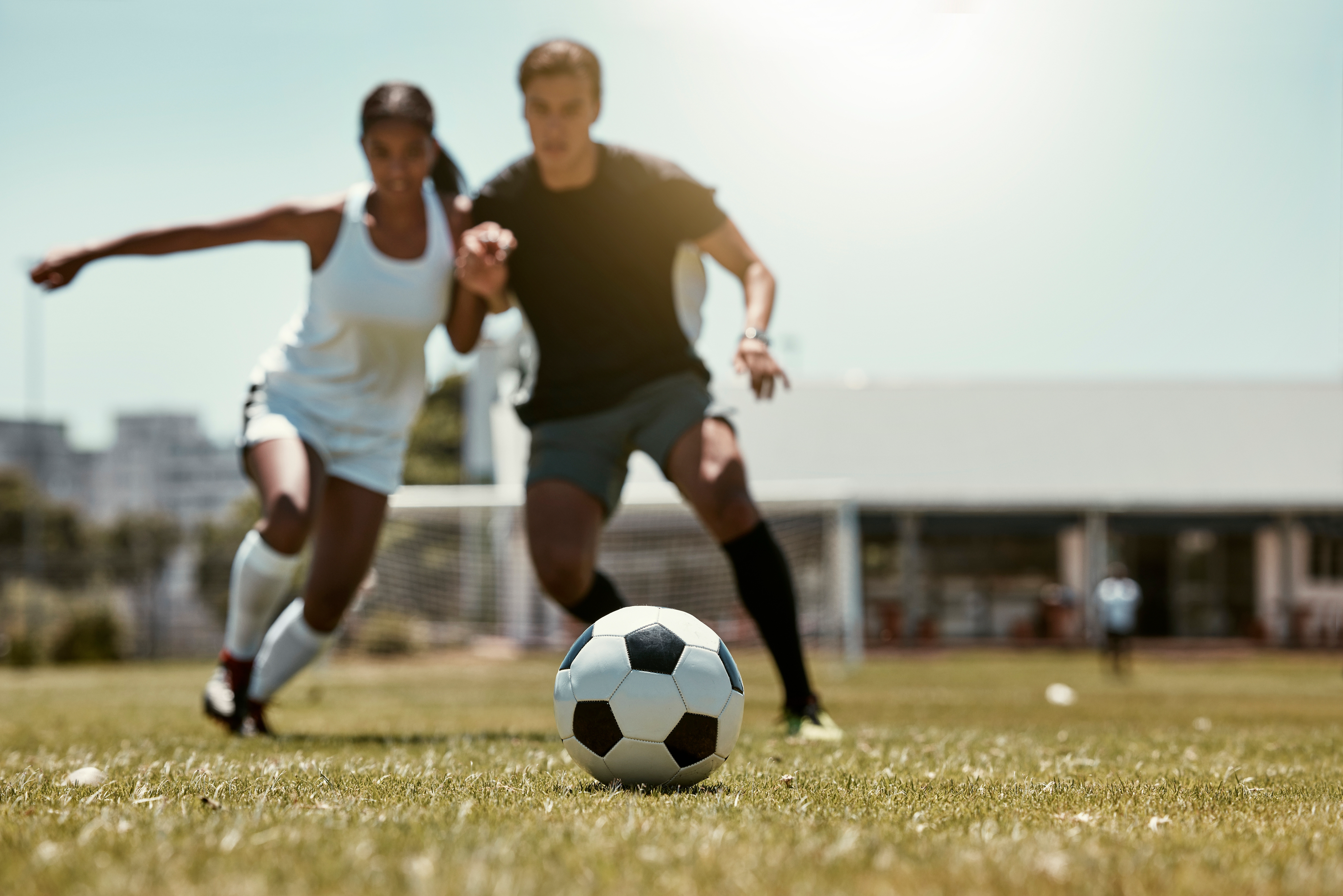 Man and woman play soccer together.
